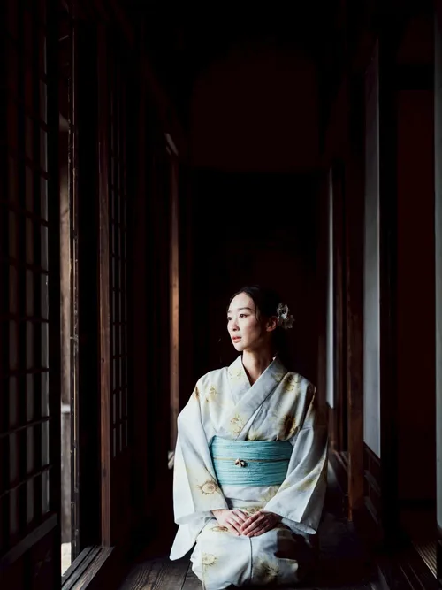 Model in kimono seated in a sunlit corridor