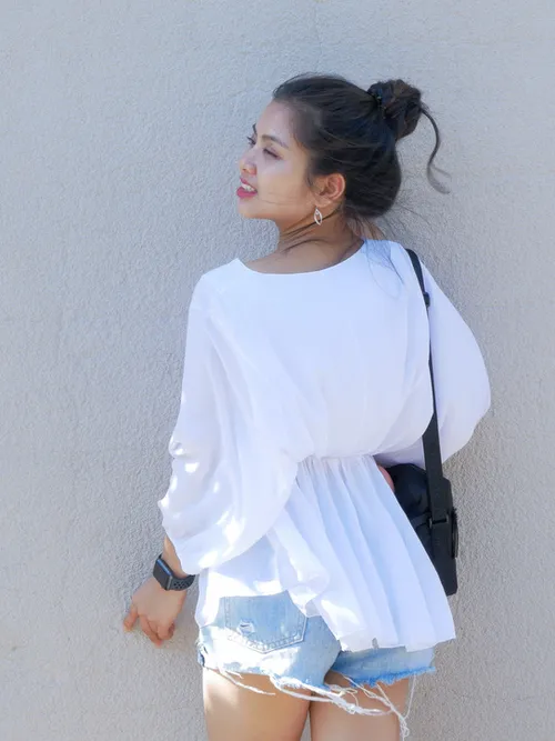 Model turning away against a pale plaster wall